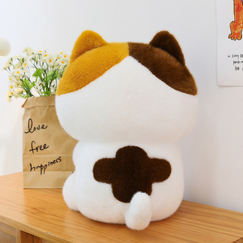 Baguette cat plush toy back view showing soft plush fabric rounded shape and tail detail in cozy indoor setting