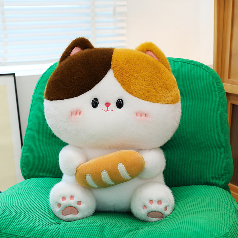 Baguette cat plush toy sitting on green chair featuring soft plush material cute face details and bread design in cozy room setting