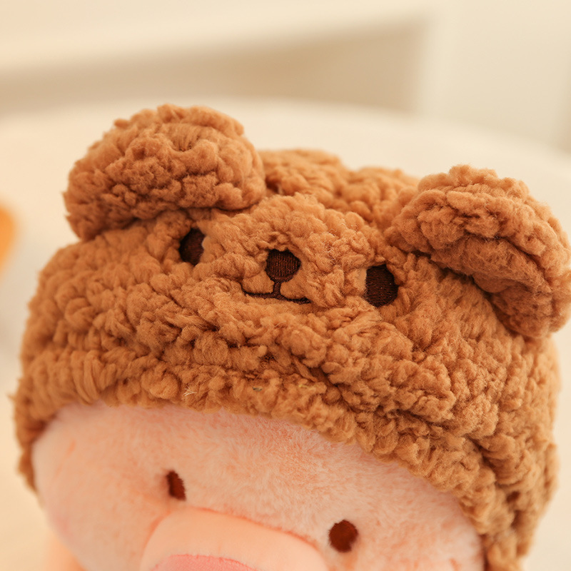 Pig plush toy in bear costume with soft curly plush hood and detailed stitching, highlighting cozy texture and cute design