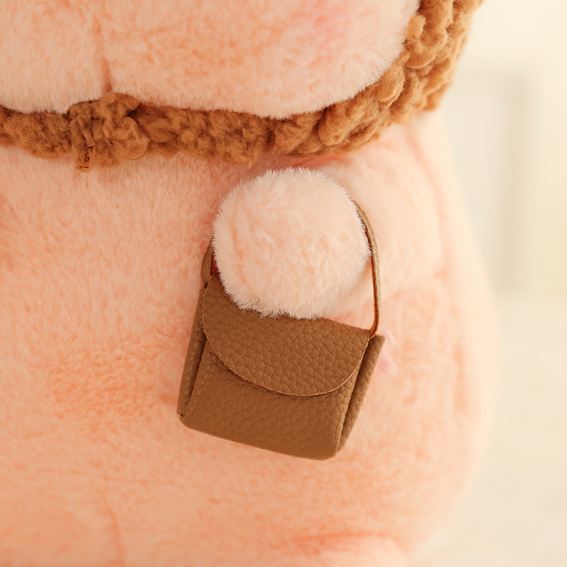 Pig plush toy in animal costume featuring a small textured pouch detail with soft plush fabric and fine stitching