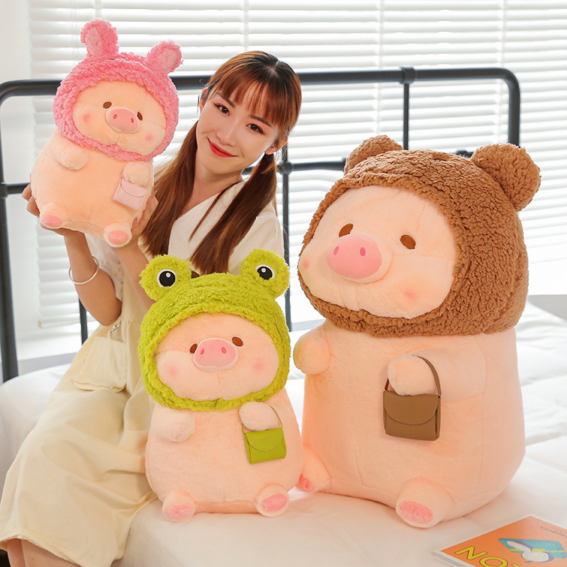 Pig plush toy in animal costume with frog, bear, and rabbit designs, shown in a cozy indoor setting, soft stuffed plush ideal for cuddling and decoration