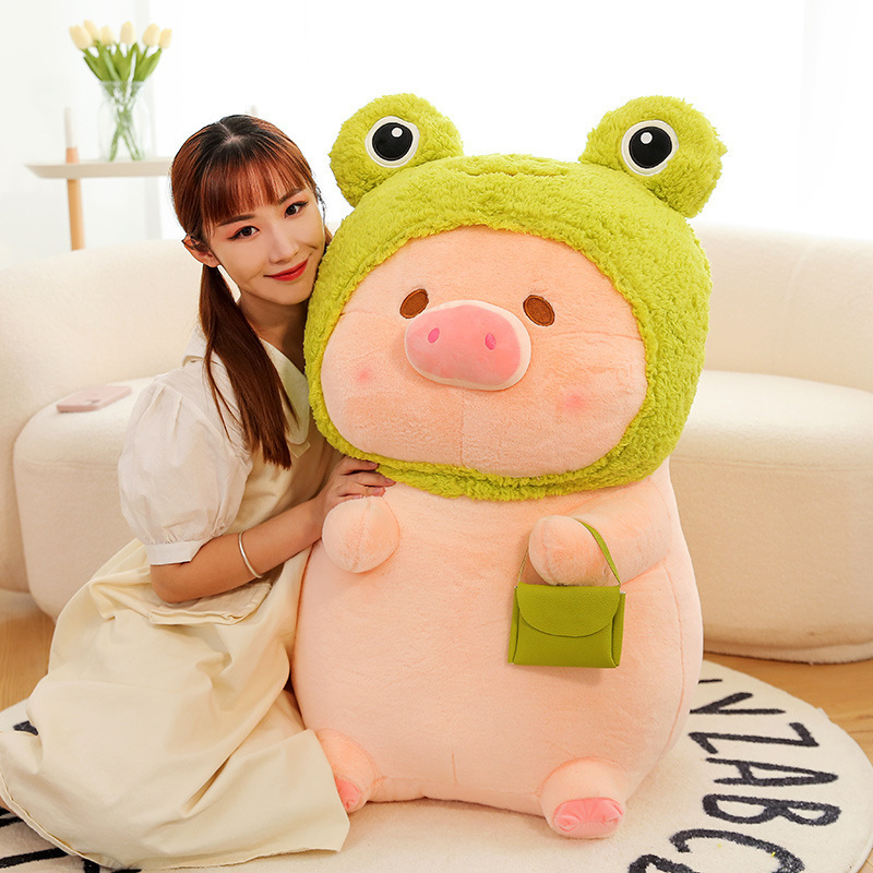 Pig plush toy in frog costume with soft plush texture and rounded shape, cozy stuffed animal for hugging or decorating sofas and living spaces
