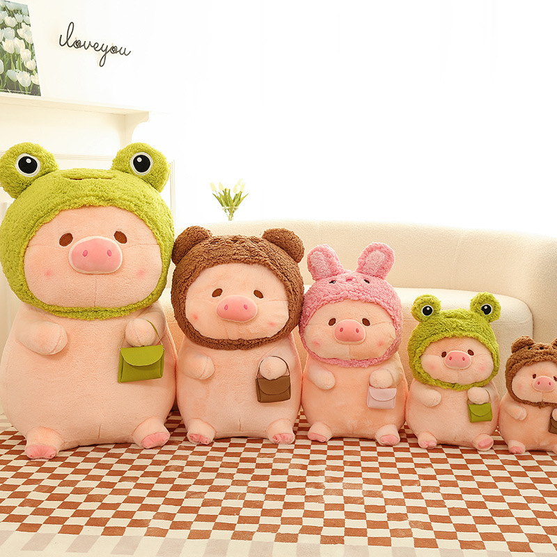 Pig plush toy in animal costume arranged in multiple sizes and styles, featuring frog, bear, and rabbit designs in a cozy indoor setting
