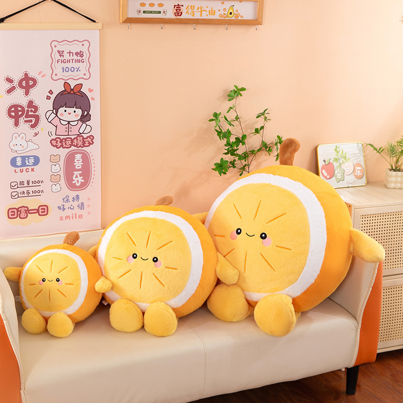 Orange plush pillows in multiple sizes placed on a sofa, featuring smiling fruit design, soft cushions for hugging, decorating, and cozy home use