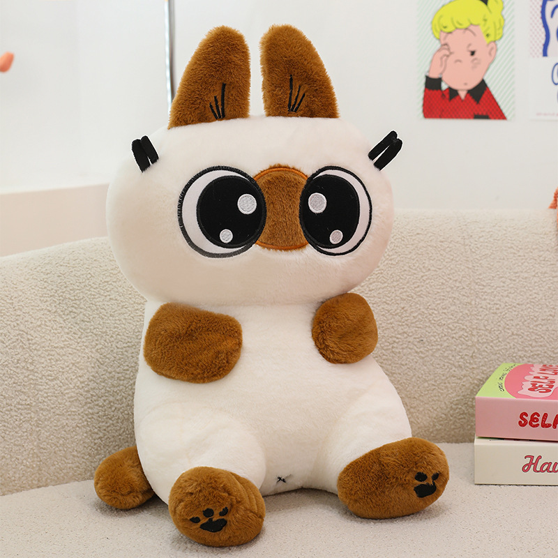 Close up of Siamese cat plush toy with big eyes and soft fluffy texture, designed for cuddling and adding a cozy touch to any room