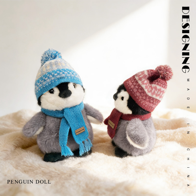 Winter penguin plush toys with blue and red scarf facing each other soft stuffed animals cozy indoor scene