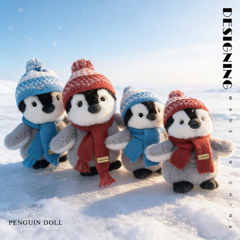 Cute winter penguin plush toys in blue and red scarf standing in snow soft stuffed animals outdoor display