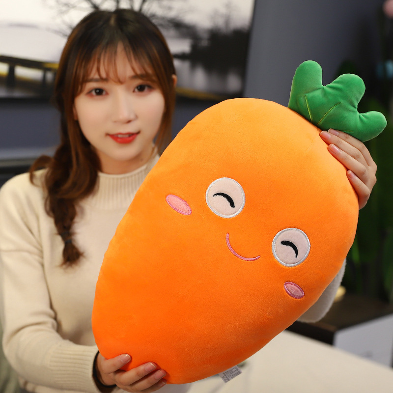 Carrot plush pillow held for size reference, soft plush cushion with embroidered face and smooth fabric texture