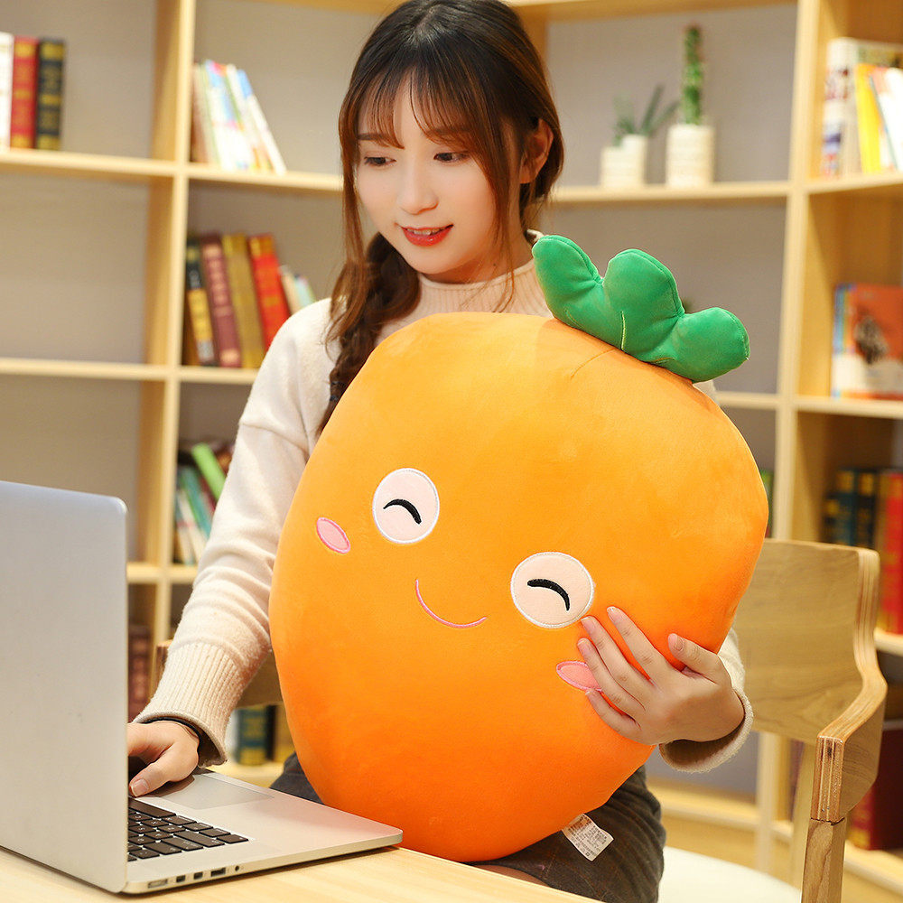 Carrot plush pillow used as a soft cushion while sitting at desk, comfortable plush support for working and relaxing