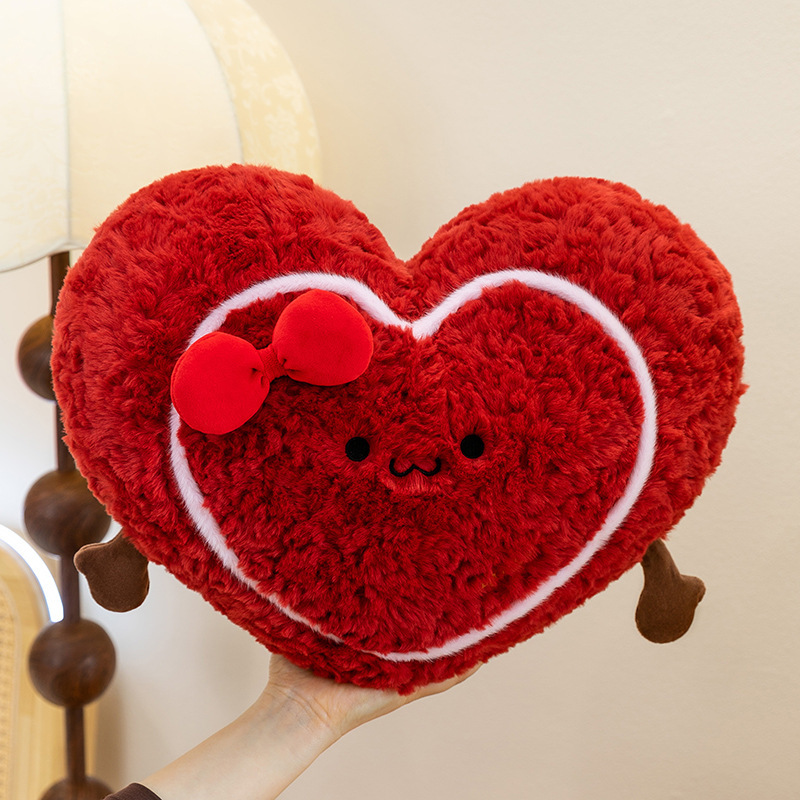 Heart plush pillow held in hand, soft red heart cushion showing size and fluffy texture for hugging and comfort