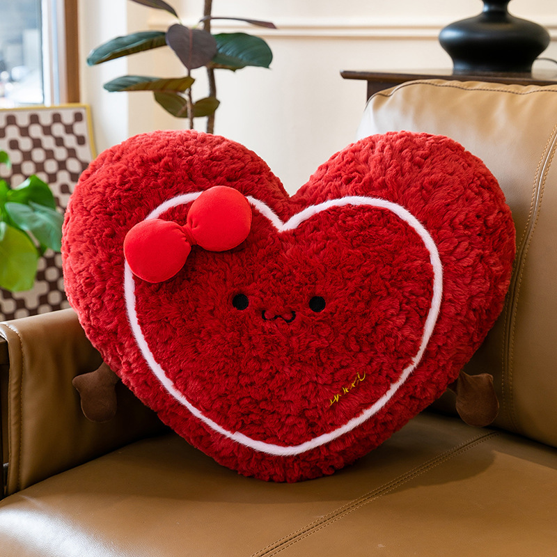 Heart plush pillow on a leather sofa, soft red heart-shaped cushion adding warmth and cozy comfort to living room decor