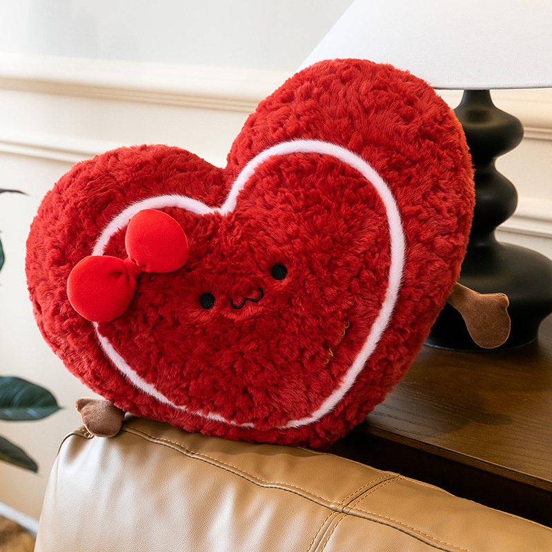 Heart plush pillow placed on a sofa edge beside a lamp, fluffy red cushion for cozy home decoration and relaxation