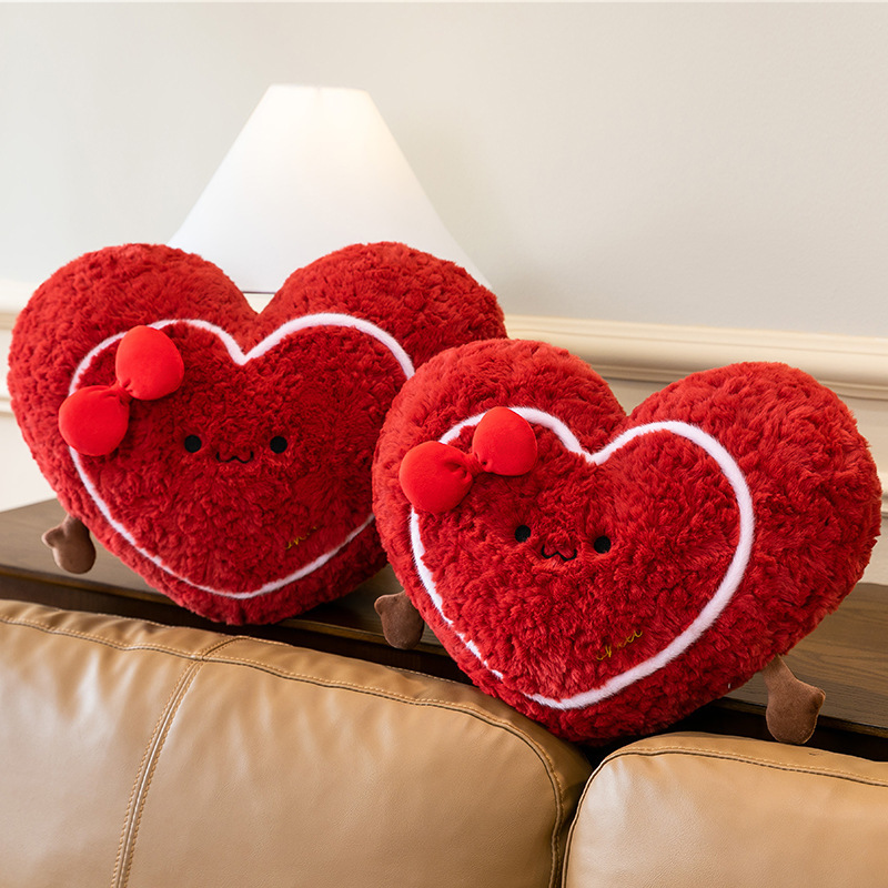 Heart plush pillows placed on a sofa backrest, soft red cushions creating a cozy and warm living room atmosphere