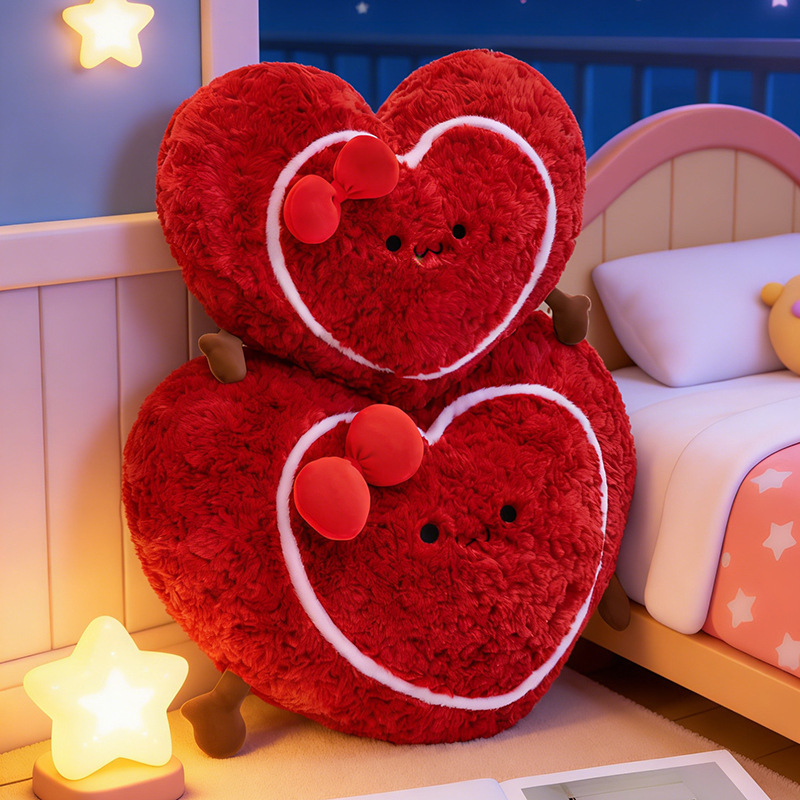 Heart plush pillows stacked near a bed with warm lighting, soft and cozy cushions ideal for bedtime comfort and decorative use