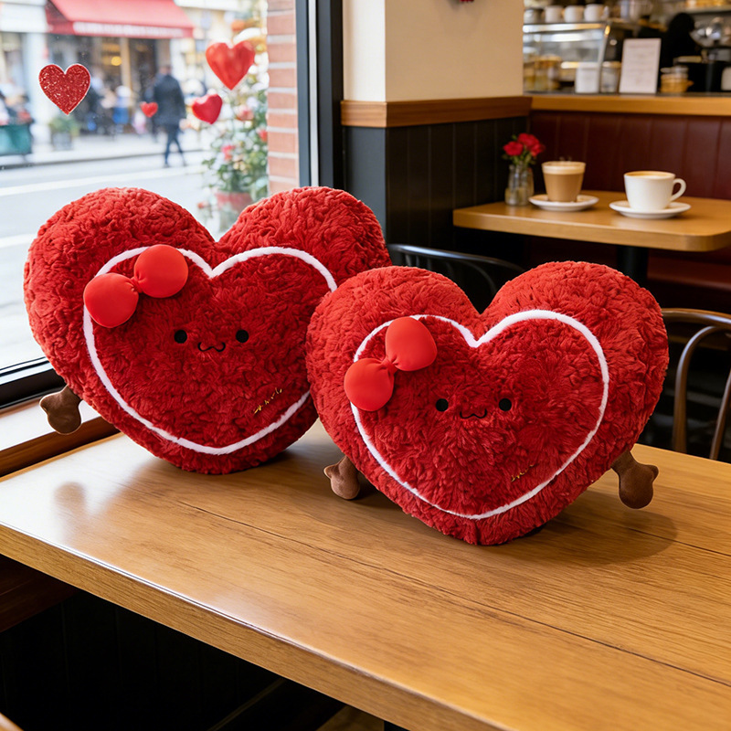 Heart plush pillows on a table in a cozy cafe setting, soft red cushions creating a warm and romantic atmosphere