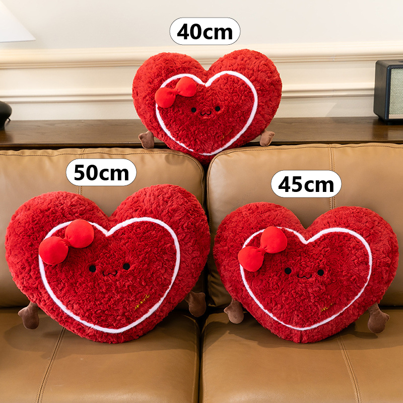 Heart plush pillow size comparison showing 40 cm, 45 cm and 50 cm cushions on a sofa for scale and visual reference