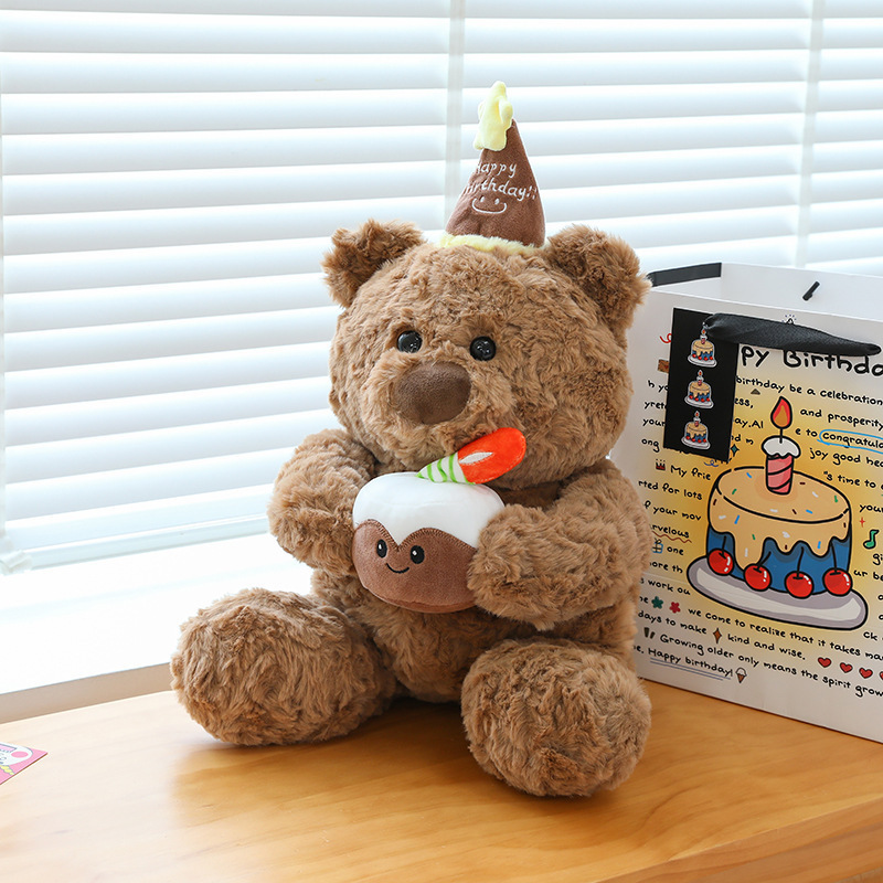 Birthday cake bear plush toy beside gift bag soft teddy bear with cake design cozy plush for birthday surprise and display