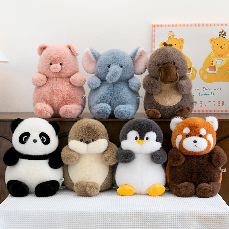 Cute animal stuffed plush toys displayed on a table, featuring panda, seal, penguin, red panda, pig, elephant and platypus, soft cozy toys for decor or gifting