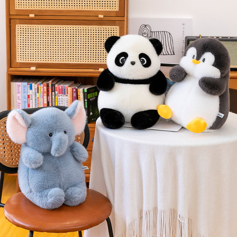 Animal stuffed plush toys including panda, penguin and elephant displayed on chair and table, soft stuffed animals for cozy home decor