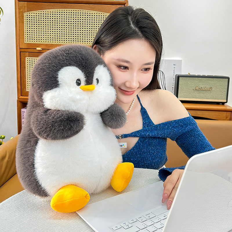 Penguin plush toy placed on a desk, soft and cozy stuffed animal for decoration, comfort and a relaxing workspace atmosphere
