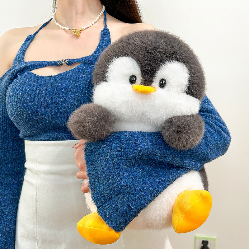Penguin plush toy held close with soft fluffy texture, cute cuddly stuffed animal for comfort and cozy everyday use