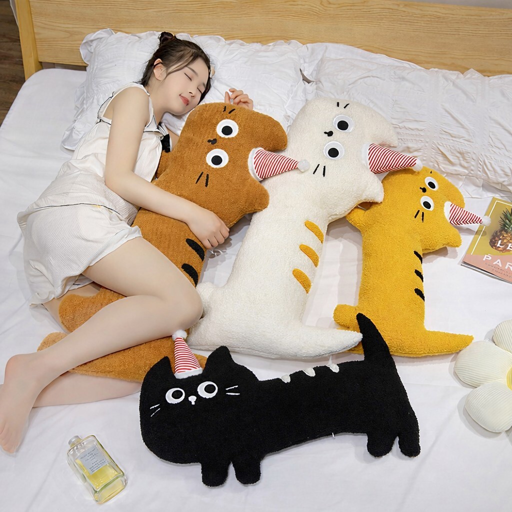 Big-eyed cat plush pillow in multiple colors on bed, long soft design for hugging, sleeping, and adding a cozy decorative touch to bedroom