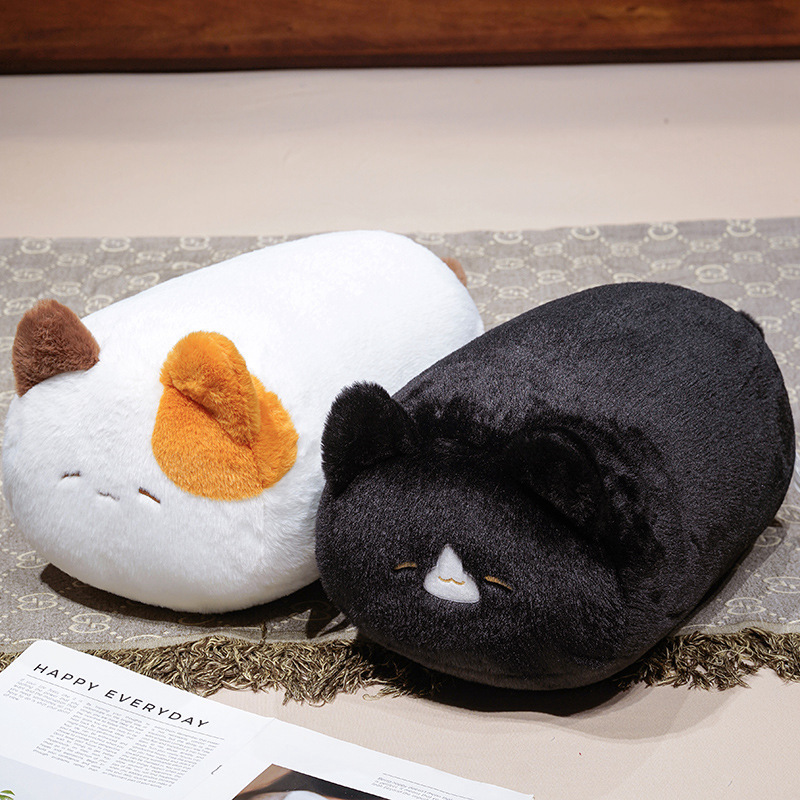 Cartoon cat plush pillow in black and calico designs placed on a bed, soft cushion for relaxing, napping, and cozy bedroom decor