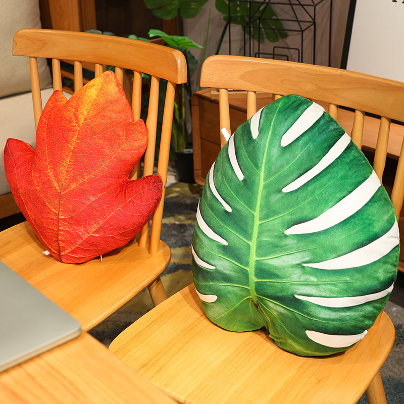 Leaf plush pillows in hawthorn and monstera designs on chairs, featuring realistic patterns and soft plush texture for home decor