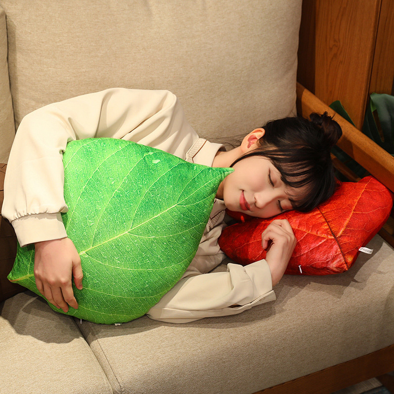 Leaf plush pillows used for napping on a sofa, soft and comfortable with realistic leaf design for cozy and relaxing moments