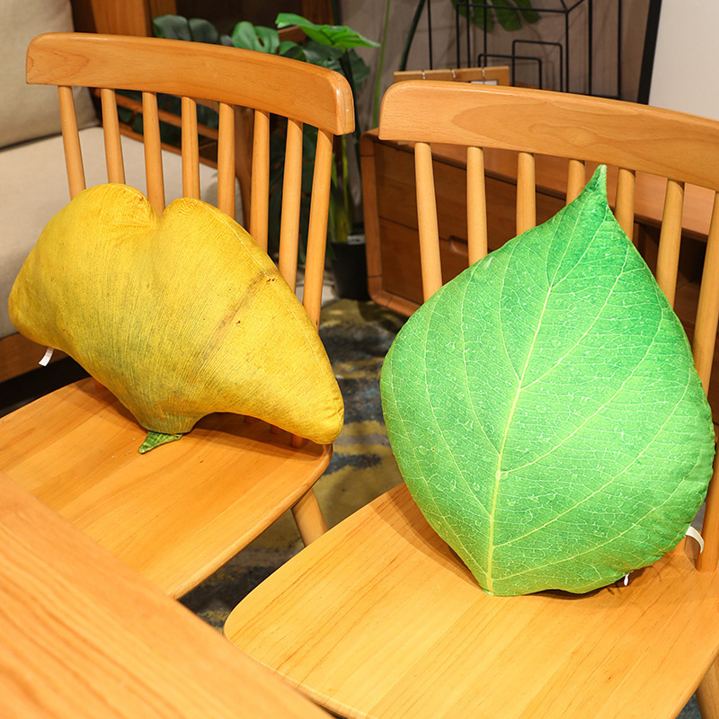 Leaf plush pillows in ginkgo and green leaf designs placed on wooden chairs, soft and decorative for cozy home styling