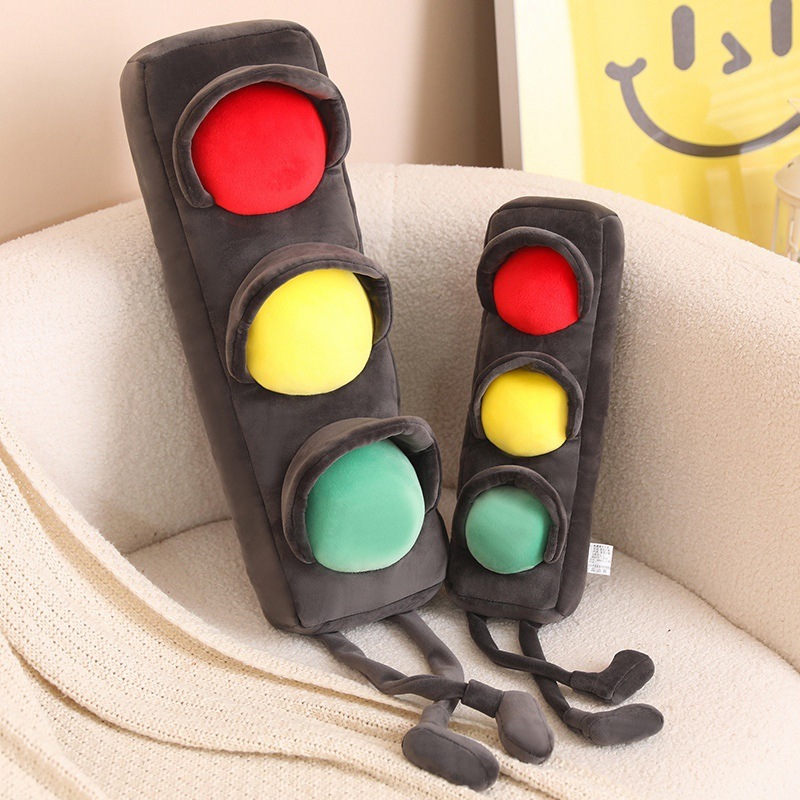 Traffic light plush pillow in two sizes on a sofa, long soft cushion with red yellow green lights and dangling legs, cozy home decor and hugging pillow