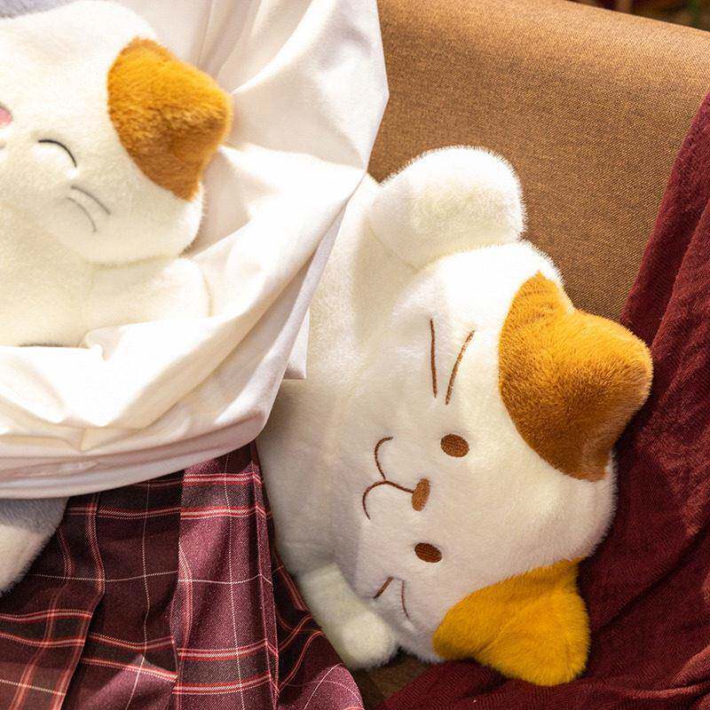 Calico cat plush pillow lying on sofa, soft and cuddly design perfect for relaxing, hugging, or adding a warm and cozy touch to home space