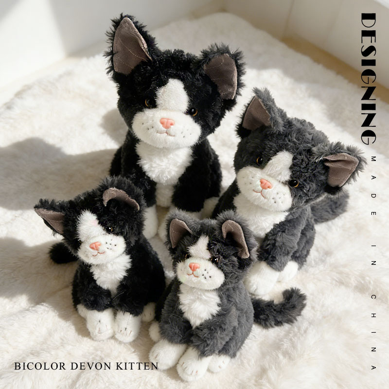 Soft bicolor Devon Rex cat plush toy with cuddly design and detailed features, displayed on a fluffy surface in a warm indoor setting