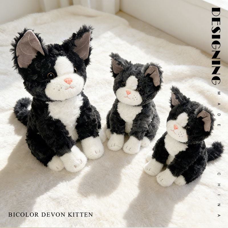 Soft bicolor Devon Rex cat plush toy with cuddly design, placed on a fluffy surface in a warm and cozy indoor setting