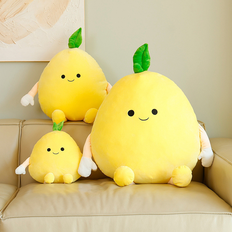 Pomelo plush pillow in multiple sizes with soft yellow fabric and cute face, arranged on a sofa to show size variation and cozy home decor styling