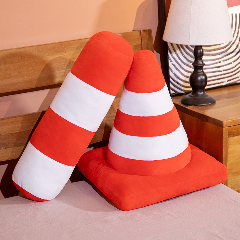 Traffic cone plush pillow and traffic bollard plush cushion with orange and white stripes placed on a bed, soft plush design for home decor and relaxation