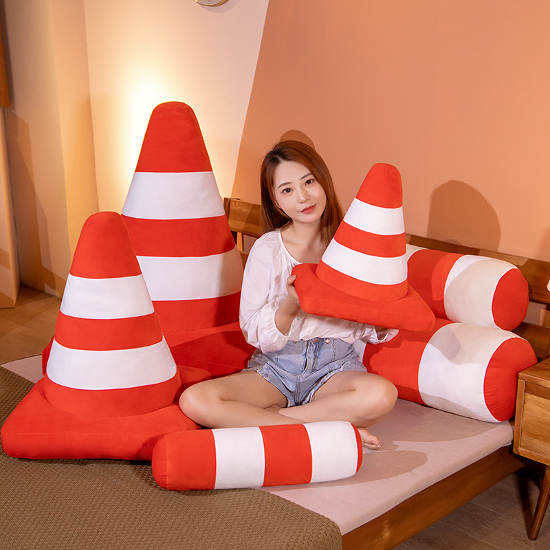 Traffic cone plush pillow in cone and bollard styles on a bed, soft cushion for lounging, relaxing, or home decor use