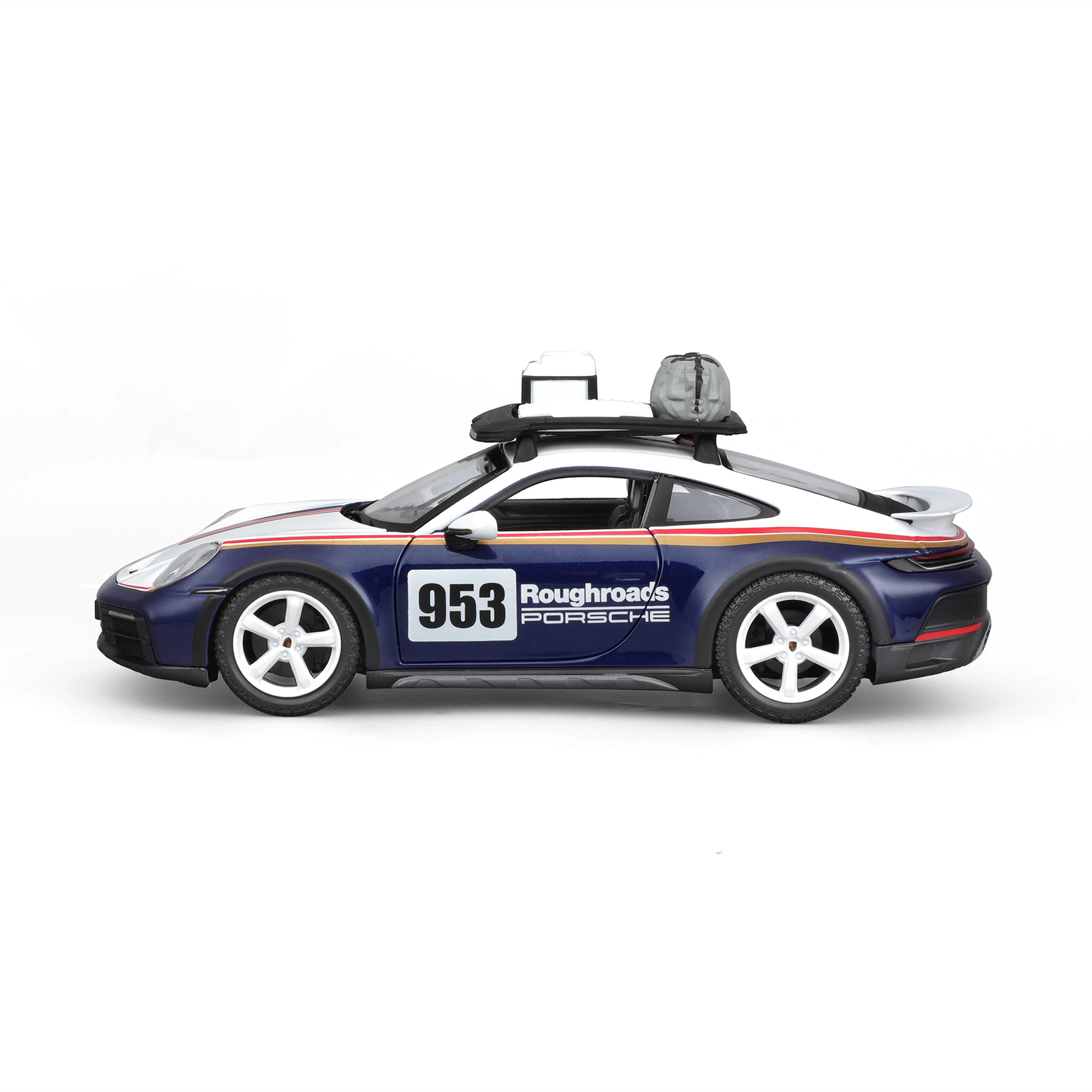 Side profile of Porsche 911 Dakar 1:24 diecast model car in #953 rally livery, featuring off-road tires, stripe detailing, and roof rack gear