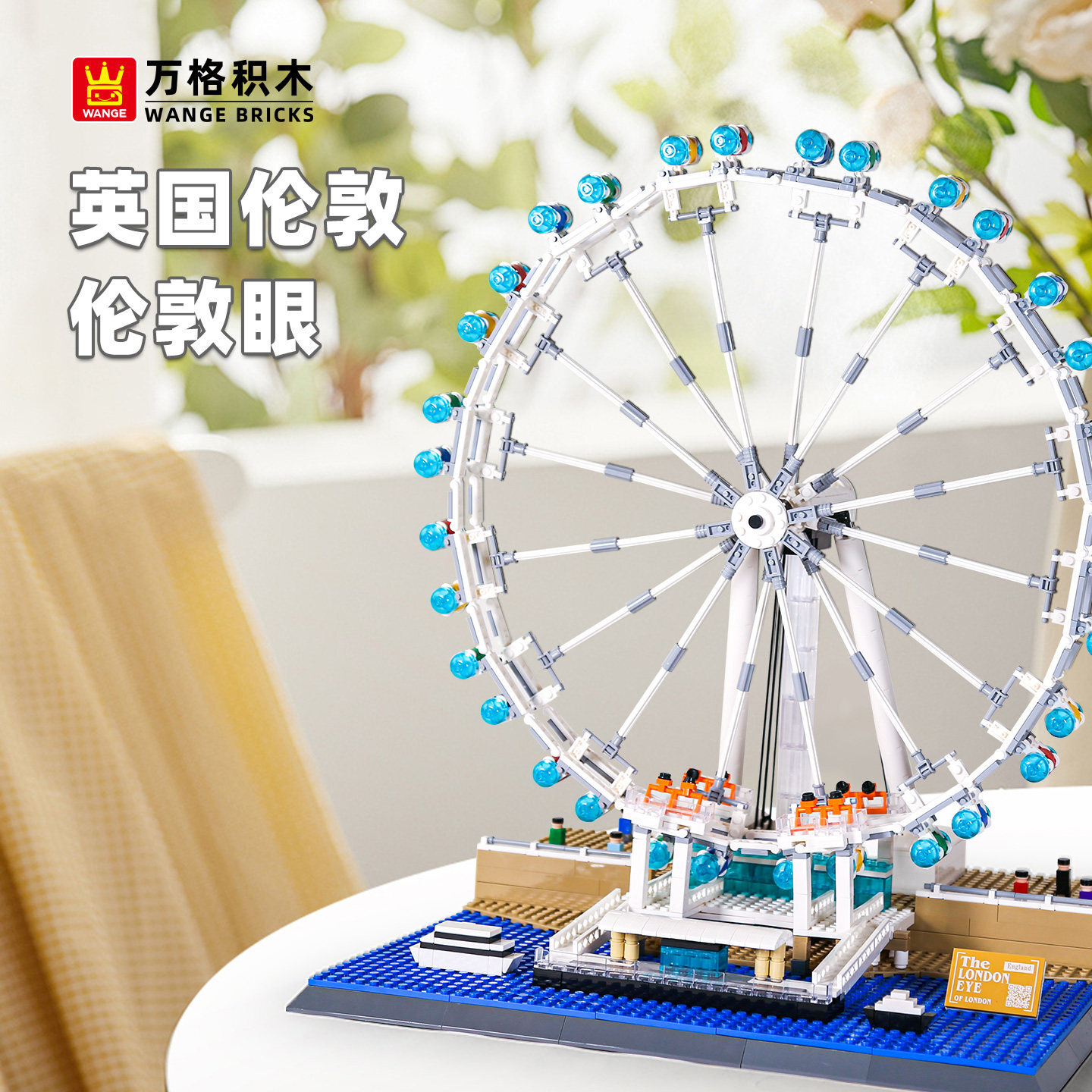 London Eye building blocks model displayed on a table, featuring detailed wheel structure, blue capsules, and architectural base in a bright, cozy indoor setting