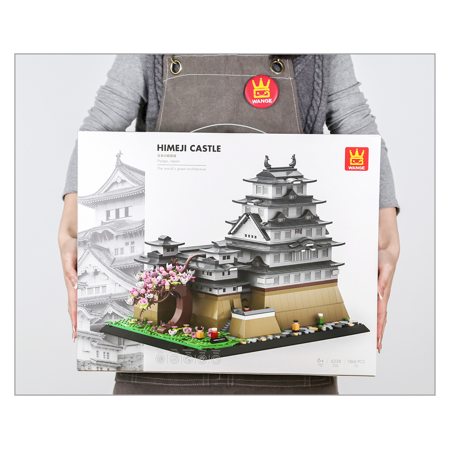 WANGE Himeji Castle building blocks box held for size reference, featuring detailed castle model artwork and architecture series packaging design