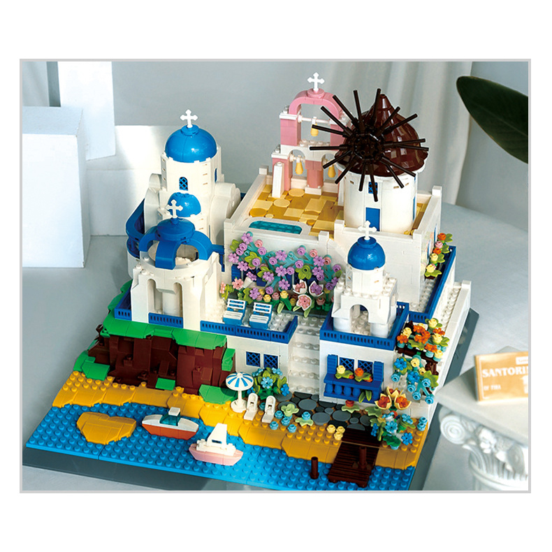 Santorini building blocks model displayed on desk with soft lighting, featuring blue domes, windmill, floral details, and coastal village atmosphere