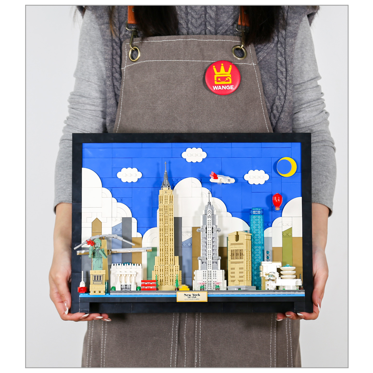 WANGE New York City Postcard building blocks completed model held in hands, highlighting framed skyline design with layered buildings and decorative city scene