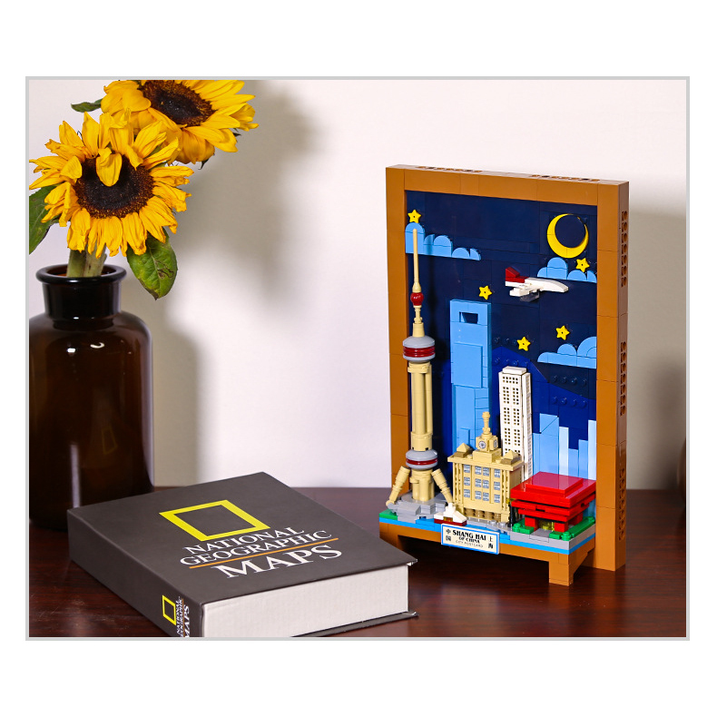 Shanghai City Postcard building blocks displayed on wooden desk with decorative flowers and book, showcasing compact skyline model as a stylish home decor piece
