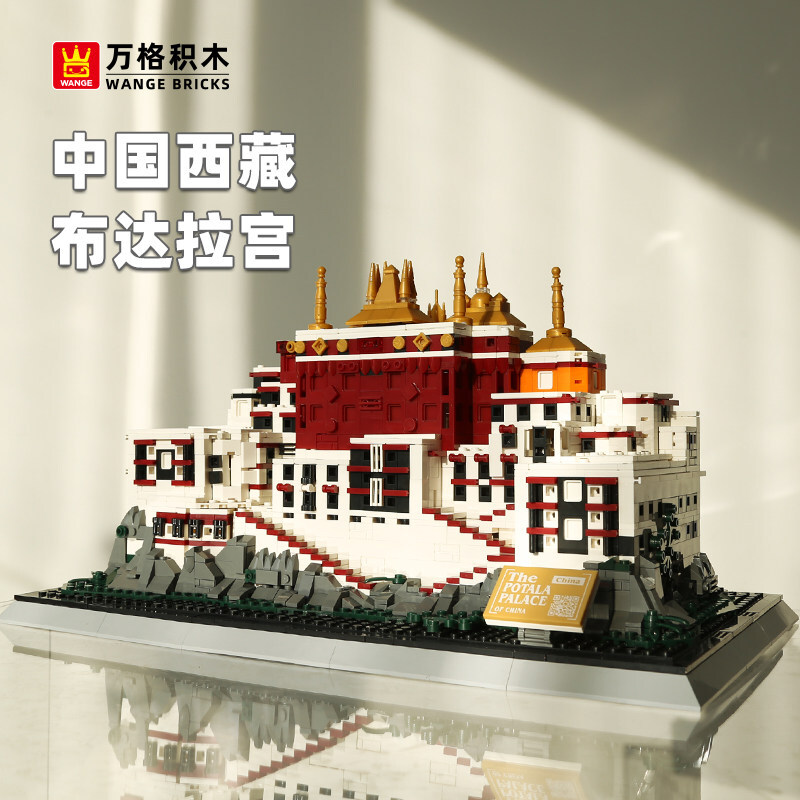 Potala Palace building blocks model with layered red and white structure, golden rooftop details, and rocky base, displayed on a reflective surface in a warm indoor setting