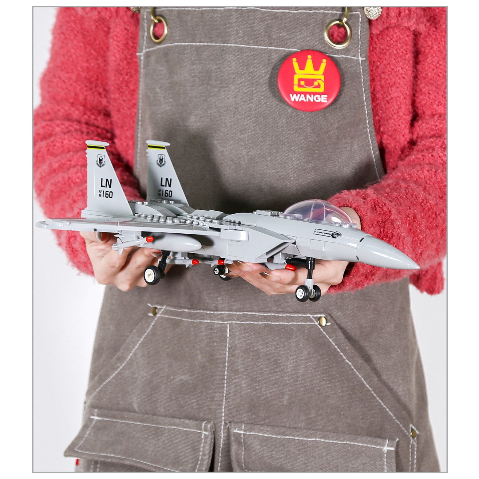 F-15 Eagle fighter jet building blocks model in hand, showcasing detailed cockpit, landing gear, missiles, and realistic twin-tail design