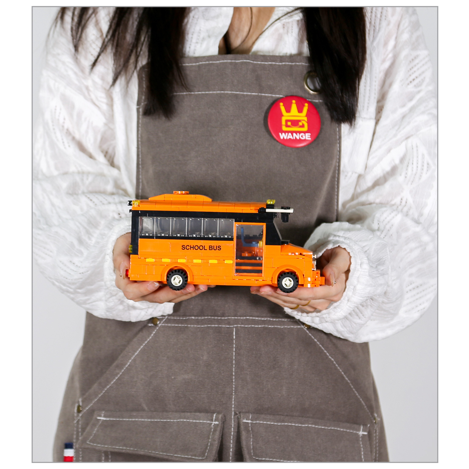 Compact WANGE School Bus building block model with bright orange body, transparent windows, and detailed city transport vehicle styling for display and collection