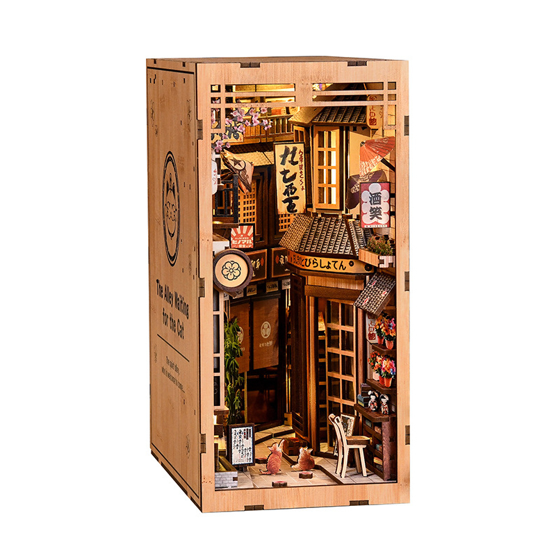 Side view of Japanese alley DIY book nook with warm lighting, wooden frame construction, miniature storefronts, hanging signs, and cozy street details