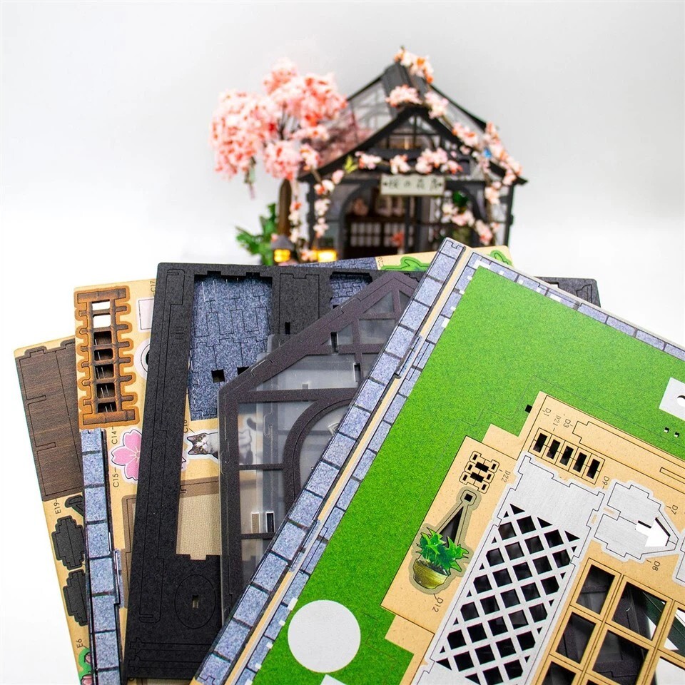 DIY miniature house kit parts and wooden assembly sheets for Spring Sakura Greenhouse with detailed printed components and handcrafted model accessories