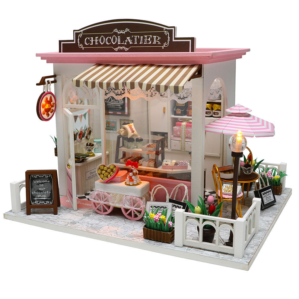 Hongda DIY miniature chocolate boutique model featuring outdoor seating, dessert cart, decorative flowers, soft lighting, and charming handmade dollhouse scenery