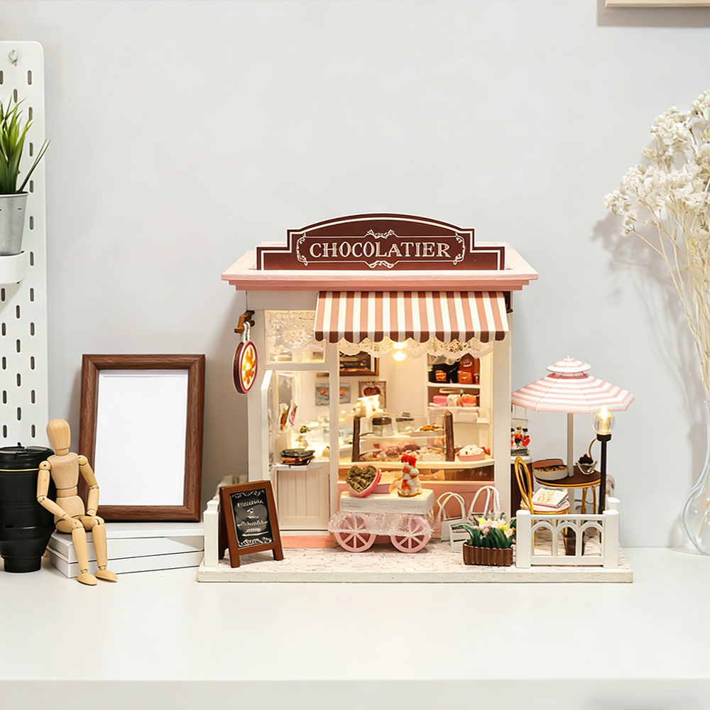 Hongda DIY miniature chocolate shop model with pastel storefront, striped awning, dessert cart, and cozy cafe atmosphere for shelf decor and creative display